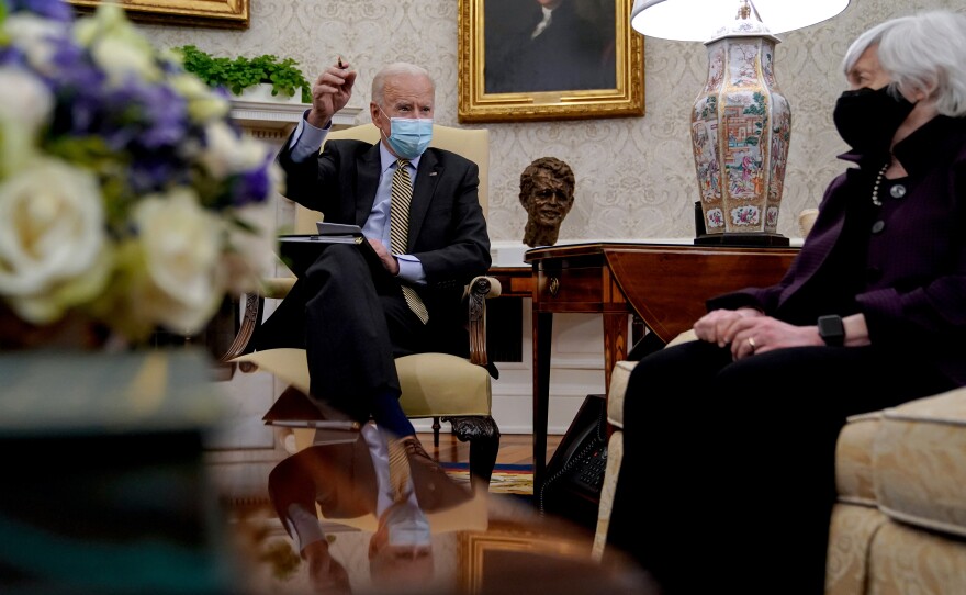 President Biden speaks as Treasury Secretary Janet Yellen listens during the weekly economic briefing in the Oval Office at the White House on April 9. Biden issued an executive order compelling Yellen and other regulators to assess the risk of climate change to America's financial system.