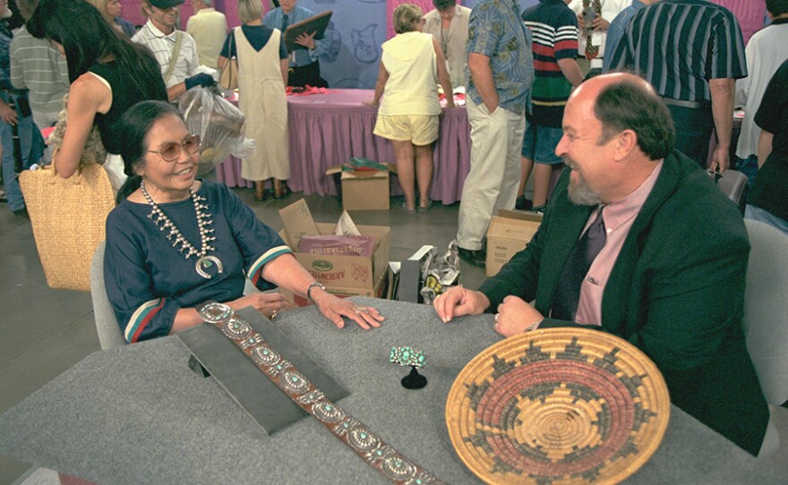 Bruce M. Shackelford (right) appraises a Navajo belt, bracelet and basket, ca. 1940, in Tucson, Ariz. ANTIQUES ROADSHOW special episode “American Stories” premieres Monday, Jan. 4, 2021 on PBS.