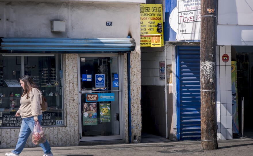 A small yellow sign hangs over the narrow alleyway leading to the Libros, Café y Jazz used bookstore in Tijuana, Oct. 18, 2024.