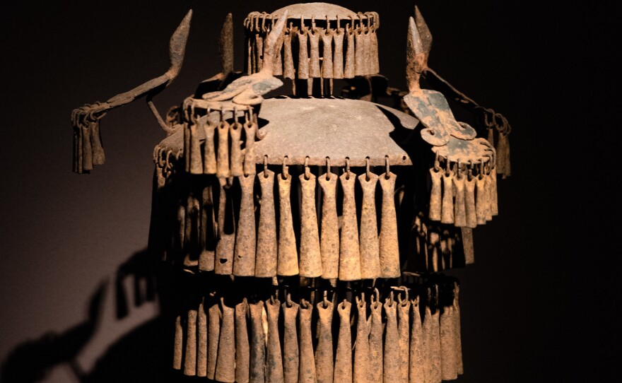 Decorated with figures, animals and plants, this type of staff would have been kept in a shrine to celebrate ancestors. The rattles would chime in the wind to attract their assistance. It's a 20th century piece from Benin.