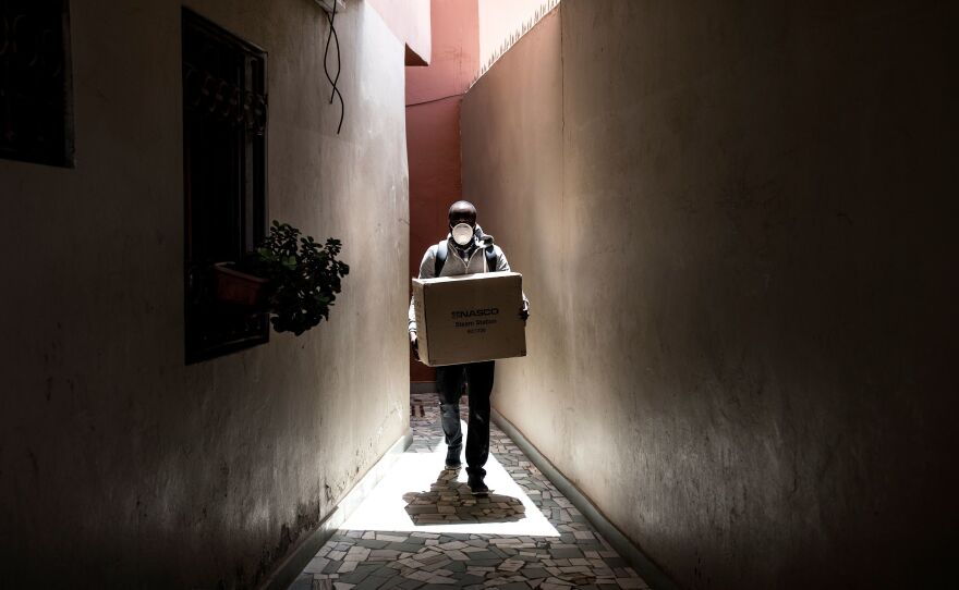 A man carries a box of protective masks to emergency workers Thursday in Dakar, the capital of Senegal. The West African country has seen relatively few confirmed cases of the coronavirus to this point β but global health officials fear that won't always be the case.