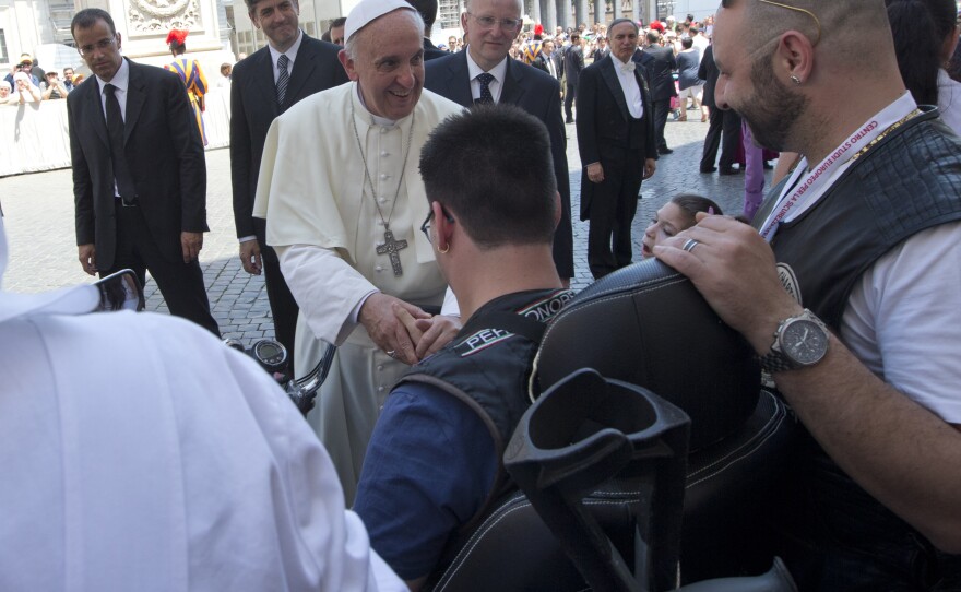 Pope Francis blesses a sick or disabled person wearing Harley-Davidson garb in St. Peter's Square, at the Vatican on Sunday.