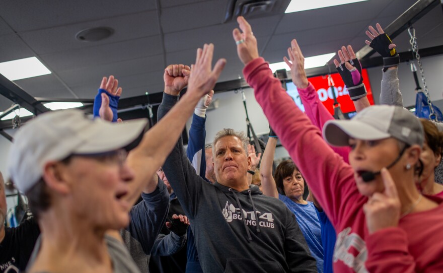 Rich Mushinsky (center), owner of Fit 4 Boxing Club, says the boxing classes provide social benefits as well — it's a place for people with Parkinson's to meet others with the same disease.