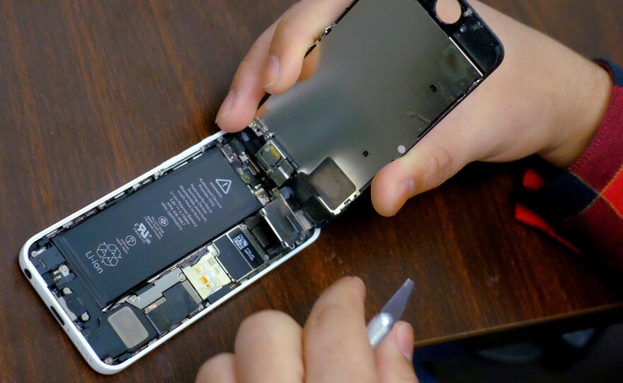 Replacing batteries will speed up phones, Apple says. Here, an iPhone is seen being repaired in a shop in New York.