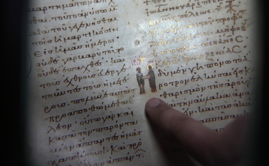 Father Theofilos, a Pantokrator monk, shows a manuscript at the library of Pantokrator Monastery in the Mount Athos, northern Greece, on Thursday, Oct. 13, 2022.