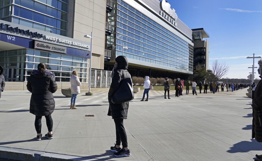 People wait in a socially distanced line to get their COVID-19 vaccinations at Gillette Stadium in Foxborough, Mass., last month. The NFL is making all 30 of its stadiums available to serve as mass vaccination sites.