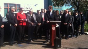 San Diego Mayor Kevin Faulconer stands in front of a group that includes City Council members and San Diego police officers at a news conference to announce a tentative salary deal for cops, Feb. 6, 2015. 