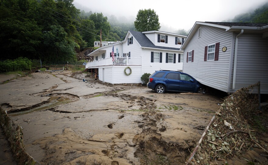 A house that was moved off of its foundation following a flash flood rests on top of a vehicle on Thursday in Whitewood, Va. Virginia Gov. Glenn Youngkin declared a state of emergency to aid in the rescue and recovery efforts from Tuesday's floodwaters.