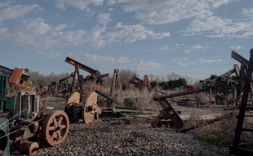 Scott Robinowitz keeps old pump jacks and other oilfield equipment in a yard at the Bird Creek field in Sperry, Okla.