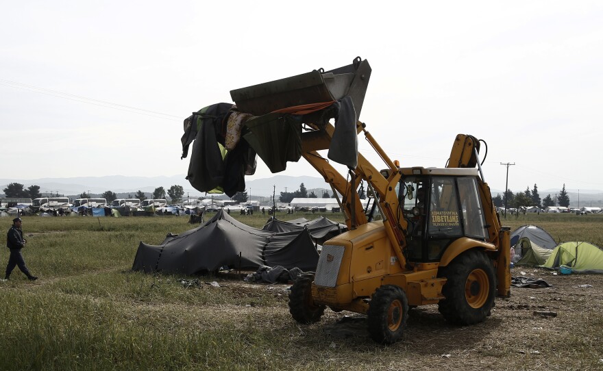 An excavator collects tents from the makeshift migrant camp near the village of Idomeni, Greece, on Tuesday.