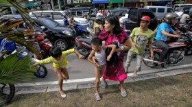 An Acehnese woman with a child tries to stop a car to go to higher ground shortly after a powerful 8.6 earthquake hit the western coast of Sumatera in Banda Aceh.
