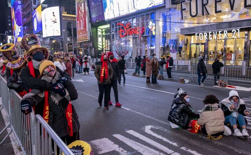 Revelers, in small groups in some areas, gather on Times Square on Friday.