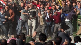 Anti-government protestors (front) clash with supporters of President Mubarak in Tahrir Square on February 2, 2011 in Cairo, Egypt. 