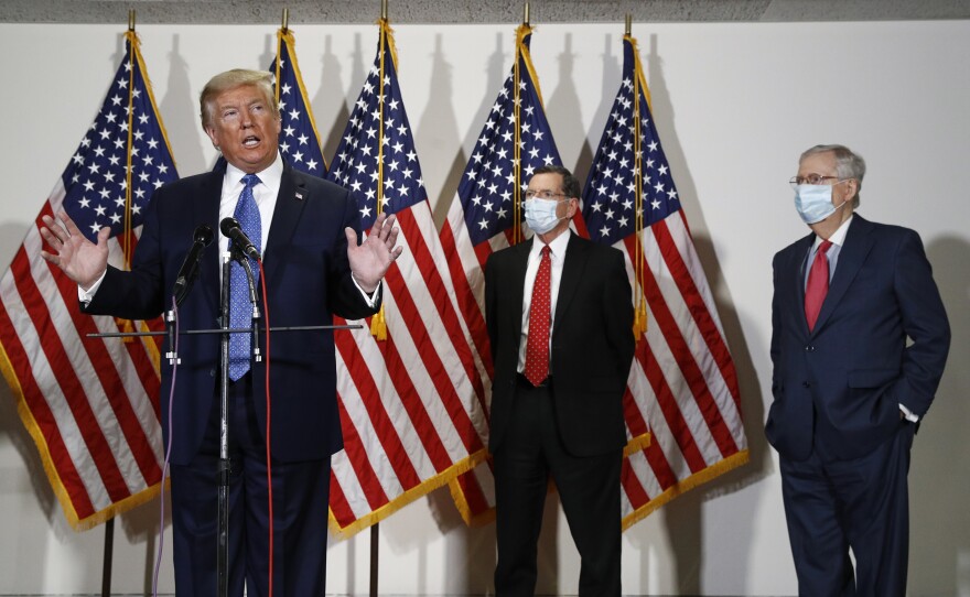 President Trump speaks to reporters May 19 after meeting with Senate Republicans at their weekly luncheon on Capitol Hill. Sen. John Barrasso, R-Wyo., and Senate Majority Leader Mitch McConnell stand at Trump's side.