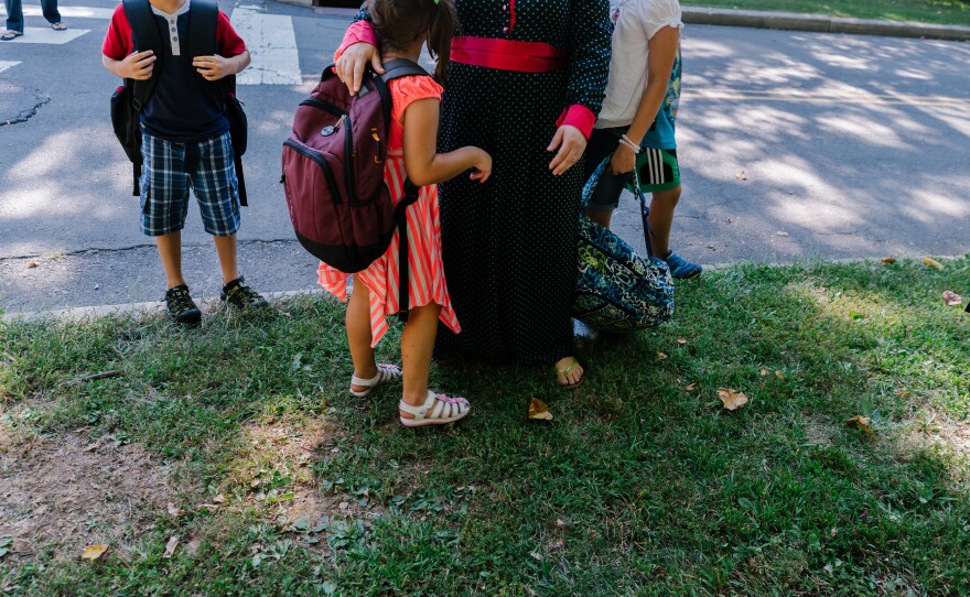 Ghada greets her children at the bus stop.