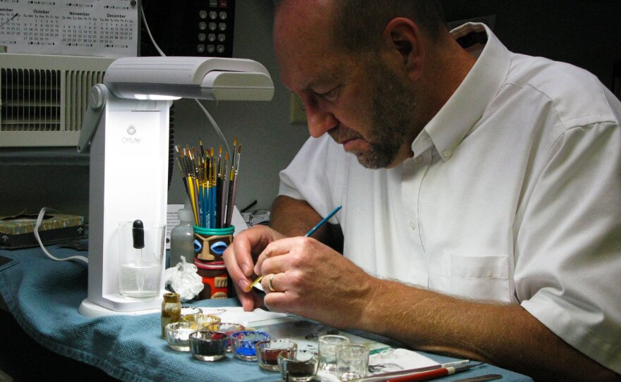 Eric Jahrling adds tiny red threads to a prosthetic eye to represent blood vessels.