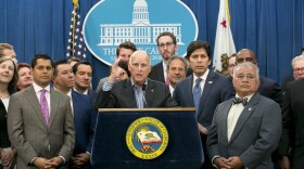 Gov. Jerry Brown, center, flanked by lawmakers from both sides of the aisle, speaks of the passage of a pair of climate change measures, Monday, July 17, 2017, in Sacramento, Calif.