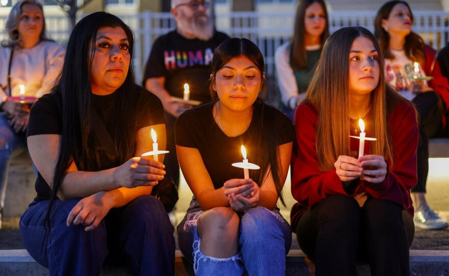 Patricia Saquilo, left, and her daughter Allyson Andrade, 13, and Hadley Mayopulos, 13, participate in a community candlelight vigil for Nex Benedict on Sunday, Feb. 25, 2024, in Owasso, Okla.