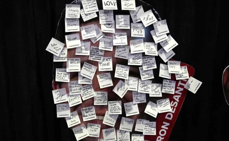 An image of Florida Gov. Ron DeSantis covered with messages written on sticky notes is displayed at an exhibit titled, "Say What You Want," featuring images of 2024 presidential candidates, during the Turning Point Action conference on July 15.