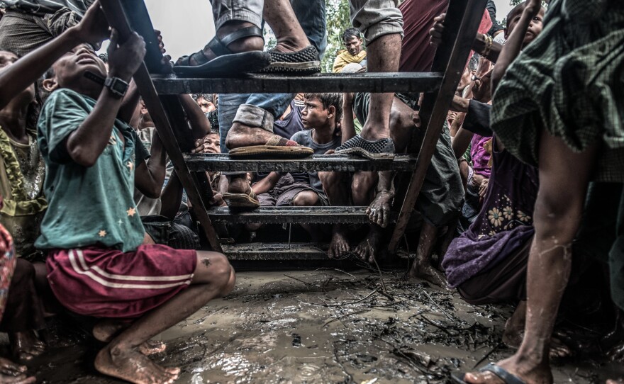 Rohingya refugees cluster around a food distribution truck in Kutupalong camp, southern Bangladesh.