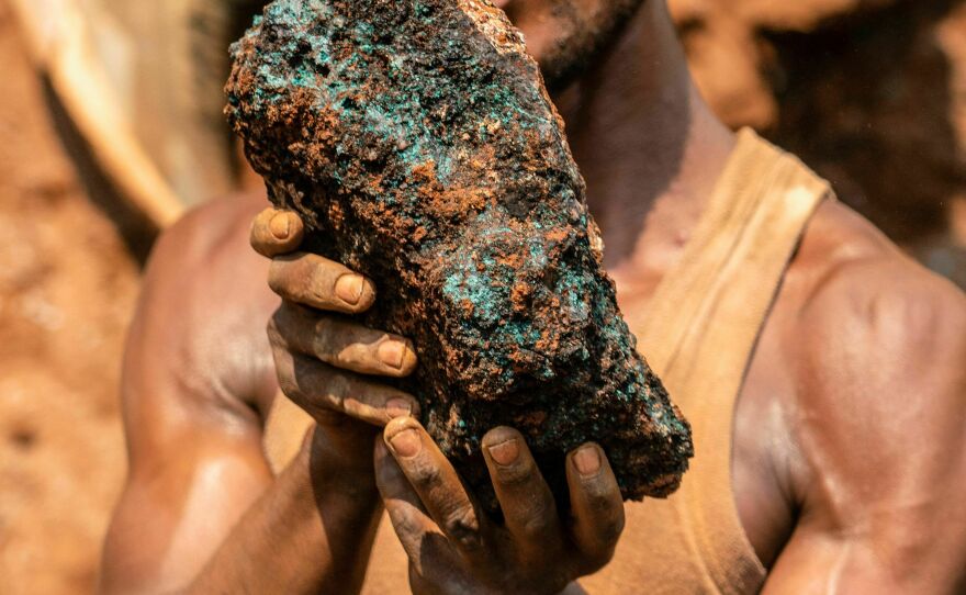 An artisanal miner holds a cobalt stone at the Shabara artisanal mine in the DRC.