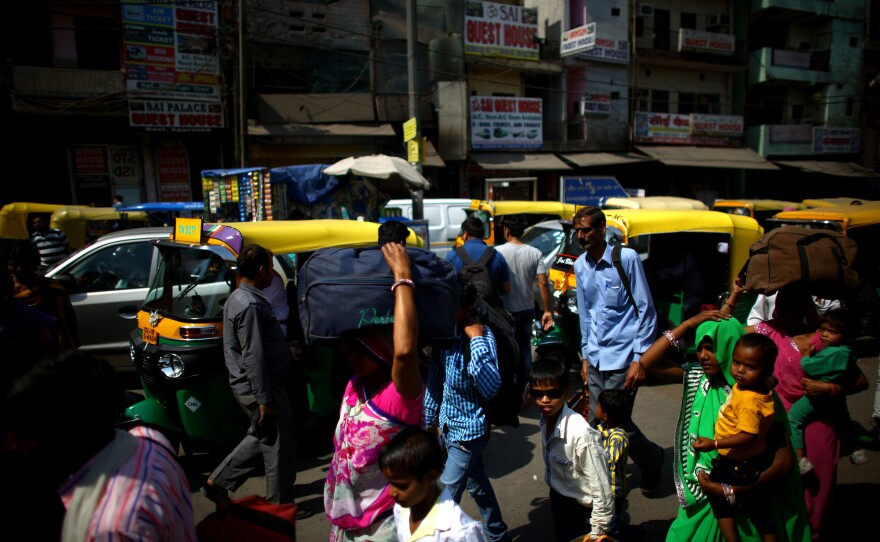 Crowds of pedestrians do battle with the traffic on the streets of New Delhi near the central train station.