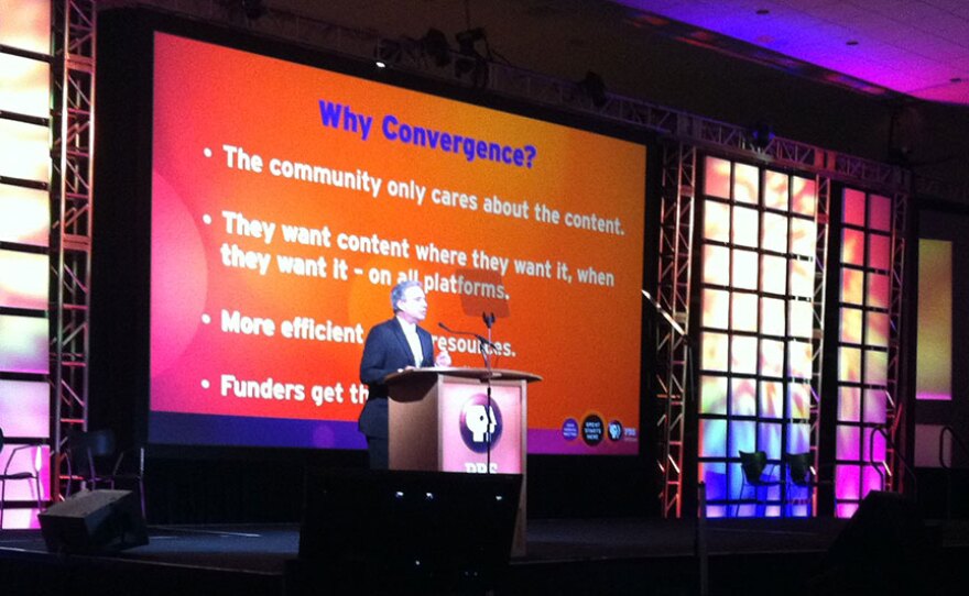 Tom Karlo at podium. The large screen behind him is titled "Why Convergence?". Presentation was given at PBS Annual Meeting, May 2013