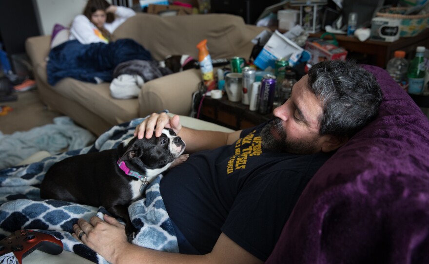 Michael Marquette pets his dog, Spring, while resting at his home in Clarksburg, Md., after a recent hip surgery to repair an injury sustained in 2009 during military duty.