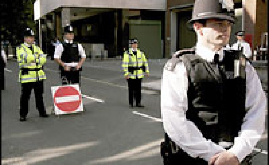 Police officers guard the entrance to City of Westminster Magistrates after the arrival of a van carrying terror suspects on Tuesday.