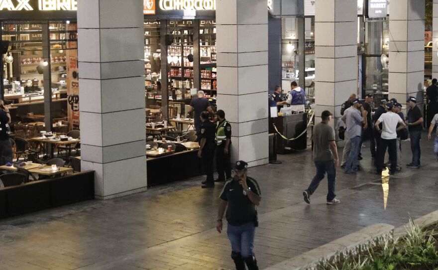 Israeli security forces gather at a shopping complex in Tel Aviv following a shooting attack in a market and restaurant district on Wednesday.