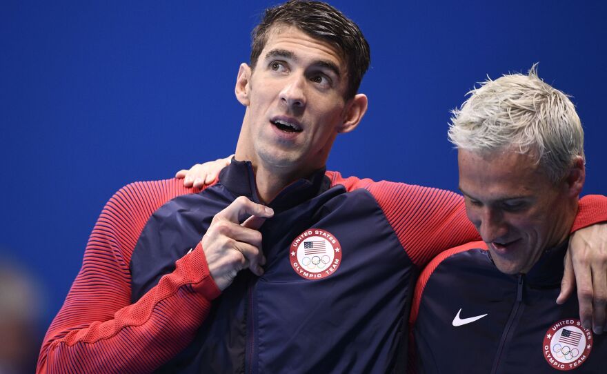 Michael Phelps (left) and Ryan Lochte celebrate on the podium after winning the men's 4x200-meter freestyle relay final earlier in the Rio Olympics.