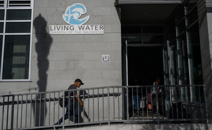 People walk into Living Water Church of the Nazarene, one of four inclement weather shelters for unhoused people in San Diego, on Dec. 20, 2023.
