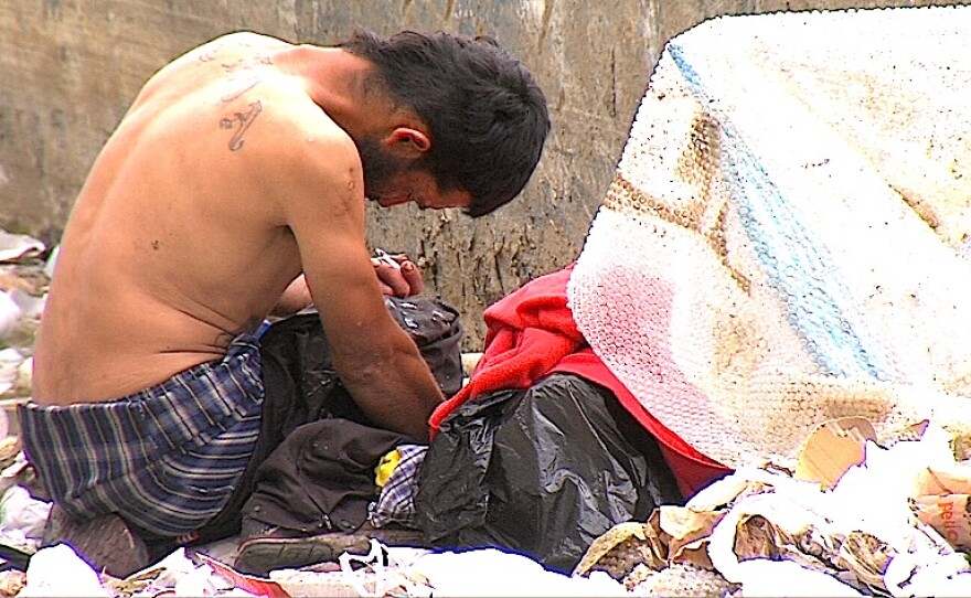 An unidentified man shoots up in a pile of garbage in Tijuana's La Zona Norte, April 25, 2015.