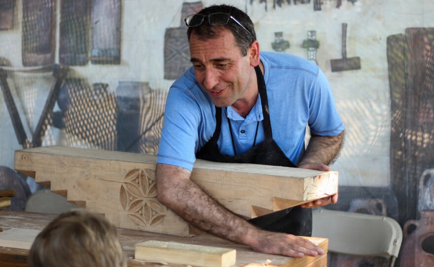 At the Smithsonian Folklife Festival in Washington, D.C., Vahagn Amiryan of Armenia prepares to carve an inscription on a block of wood that would sit atop the "mother pillar" inside a traditional house in his country.