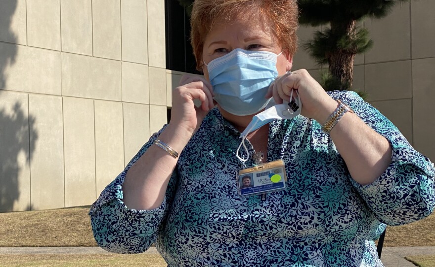 Monique Imroth, director of emergency management at UC San Diego Health, adjusts her face covering while standing outside the medical system's Hillcrest location, Nov. 2, 2020.