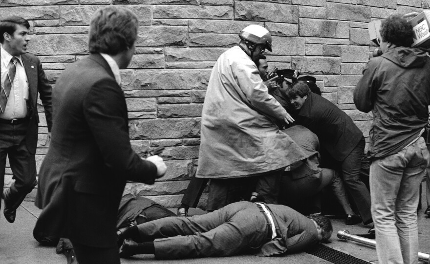 Secret Service agent Timothy J. McCarthy, foreground, Washington policeman Thomas Delahanty, center, and presidential press secretary James Brady, background, lie wounded on a street outside a Washington hotel after shots were fired at President Reagan on March 30, 1981.