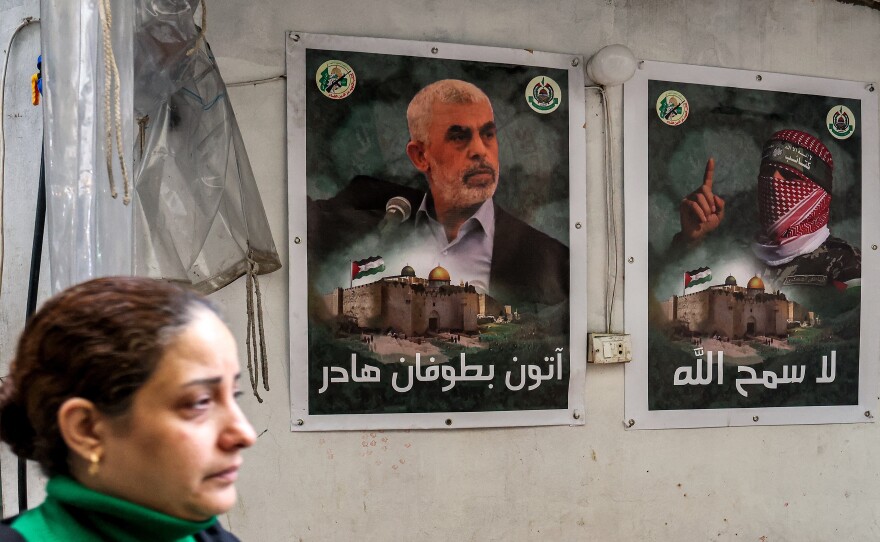 A woman walks past posters depicting Yahya Sinwar, the head of Hamas in Gaza, plastered on a wall in the Burj al-Barajneh camp for Palestinian refugees in Beirut's southern suburb on Feb. 5.