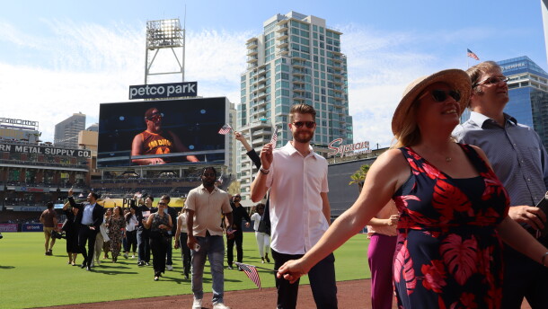 New U.S. citizens walk off the Petco Park field after taking the Oath of Allegiance in a naturalization ceremony on Wednesday, Aug. 21, 2024.