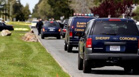 Sheriff coroner vans drive to the bodies of the shooting victims at Oikos University as police survey the scene on April 2, 2012 in Oakland, California.