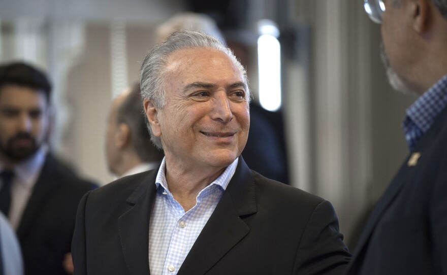 Brazilian President Michel Temer flashes a smile during a meeting in Rio de Janeiro on Sunday. The embattled leader has been one of the subjects of a vast, yearslong corruption probe that has snared many of the country's most powerful politicians and business people.