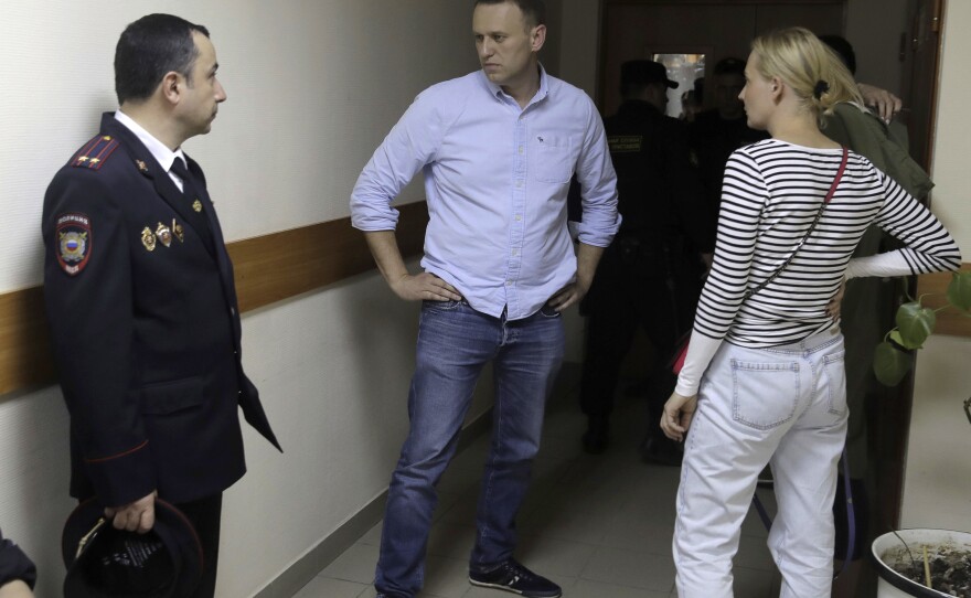 Russian opposition leader Alexei Navalny, center, and his wife Yulia talk before a hearing in a Moscow court on Monday. Navalny was arrested Monday morning.