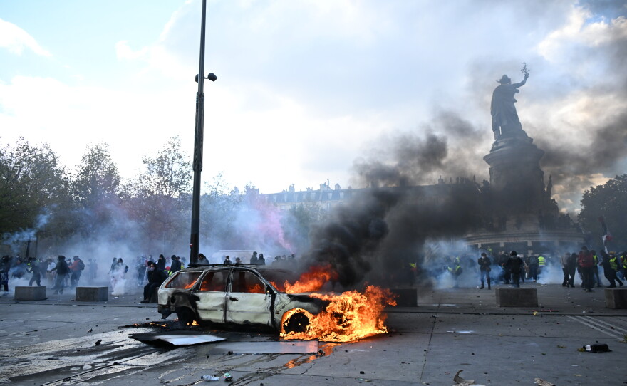 A car burns at Place de La Republique during a protest against rising living costs in Paris on Saturday.