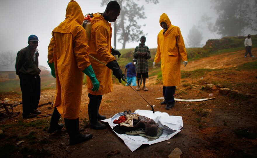 Body collectors spray bleach on a 3-year-old boy's body after he died from cholera.