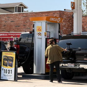 A woman cleans her windshield as another woman pumps gas at a Circle K gas station in Chula Vista, March 5, 2026.