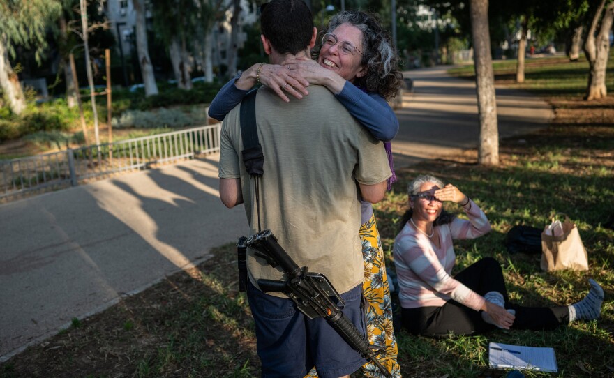 Yifah Sahar embraces her son, an Israeli soldier who is not serving in Gaza, after she attended a meeting with a newly formed group of mothers calling to end the Gaza war. She says there is no contradiction between supporting her son and opposing the ground invasion of Gaza.