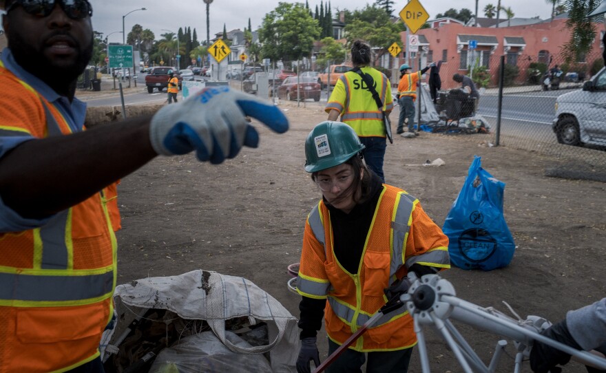 City crews clean up what's left of a homeless encampment near 19th and L Streets in San Diego on Friday, Aug. 15, 2025.