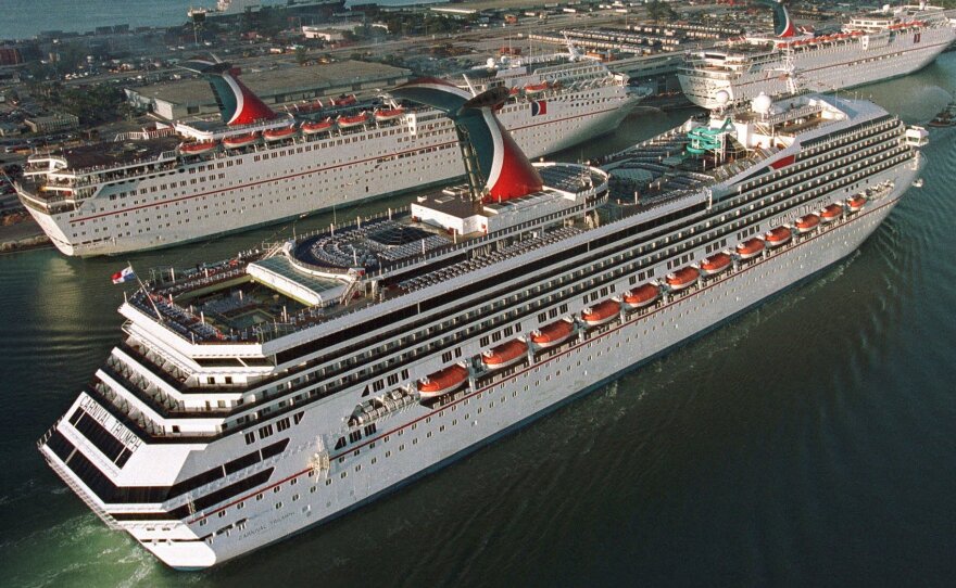 In a photo from 1999, the Carnival Cruise line Carnival Triumph, foreground, arrives in Miami. Measuring 893 feet in length, the ship has been adrift in the Gulf of Mexico for more than 24 hours, after a fire hit its engines.