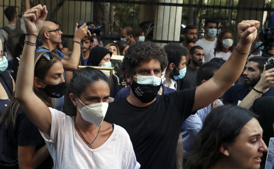 Tracy and Paul Naggear, the parents of 3-year-old Alexandra, who was killed in last year's massive blast, raise their fists during a protest outside the home of caretaker Interior Minister Mohamed Fehmi, in Beirut, July 13. A year after the deadly blast, families of the victims are seeking justice for their loved ones.
