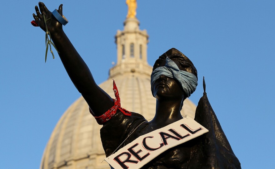 A sign that reads "recall" hangs on a statue in front of the Wisconsin state Capitol last month in Madison. In the state Senate, as many as 16 senators — Republicans and Democrats alike — could face recall elections this year.