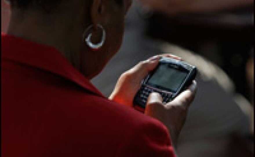 A woman works on her BlackBerry phone on Aug. 21, 2008, in Chester, Va., after she received instructions explaining how to get a text message from the Obama campaign announcing the identity of his running mate.